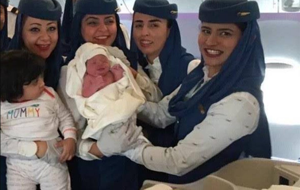  Gift from above ... Cabin crew pose with baby born during flight