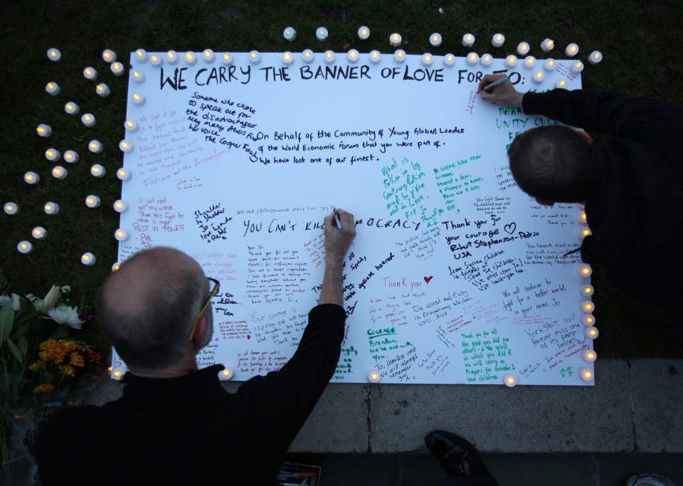  People sign a white board of condolences