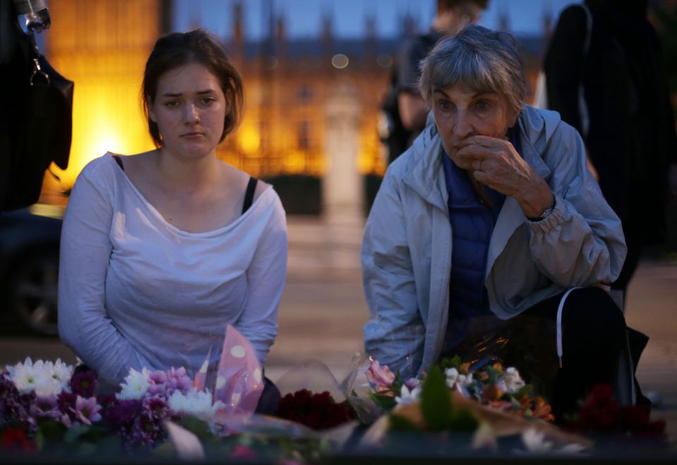  Saddened members of the public place floral tributes...to pay respect