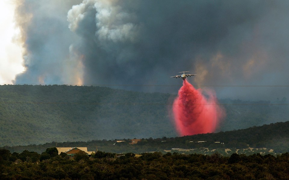 A fire fighting plane drops fire retardant on the Dog Head Fire