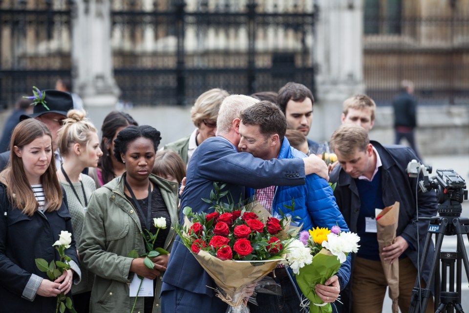 John Cryer MP, chair of the Parliamentary Labour Party, and Iain McNicol, general secretary of the Labour Party, share a hug as they lay flowers in Parliament Square