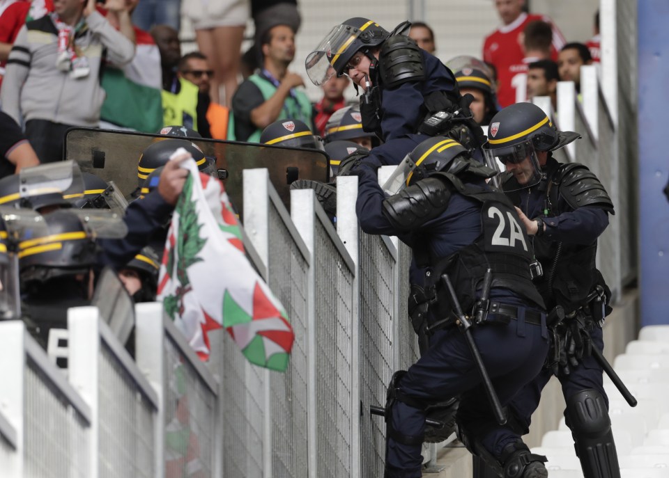 French riot police officers climb over the fence at the stadium in Marseille