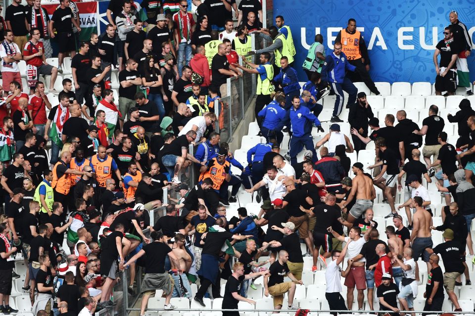 Match stewards (in blue) try to control fans from Hungary at the Stade Velodrome