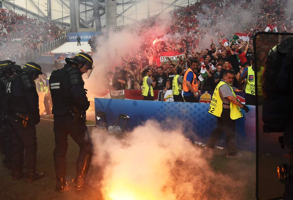 French riot police have flares thrown towards them during Hungary's clash with Iceland