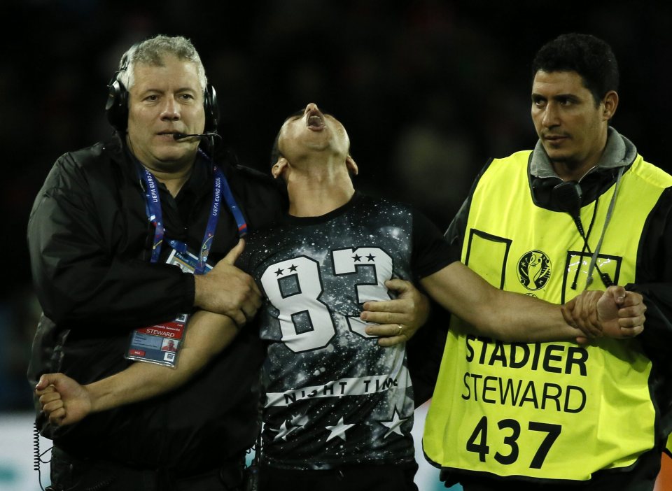  The overjoyed fan is escorted off the pitch