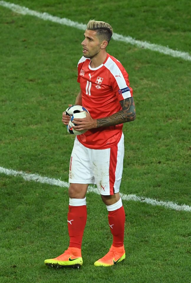  Valon Behrami holds the deflated match ball after his tackle