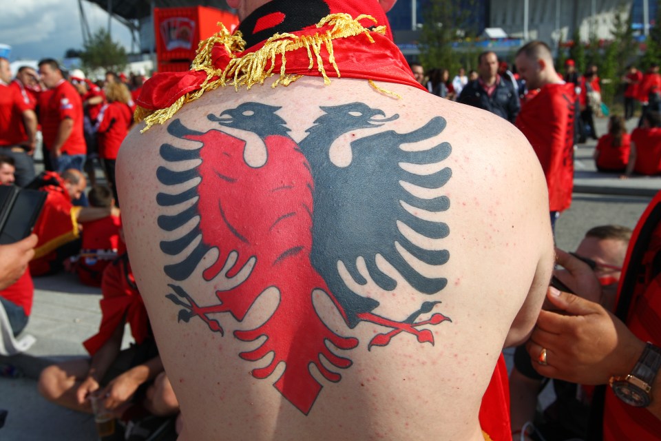  Albanian fan has huge red-and black crest across his back at his country's game against Romania