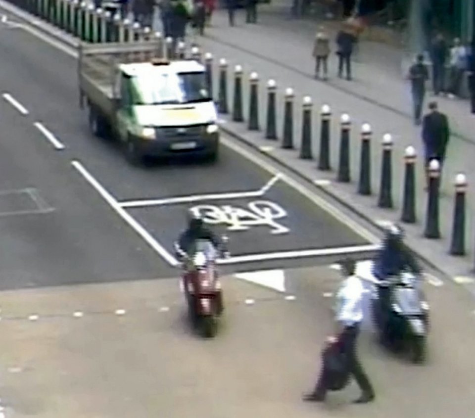 The mopeds drive either side of him, with the man forced to stop to let them through