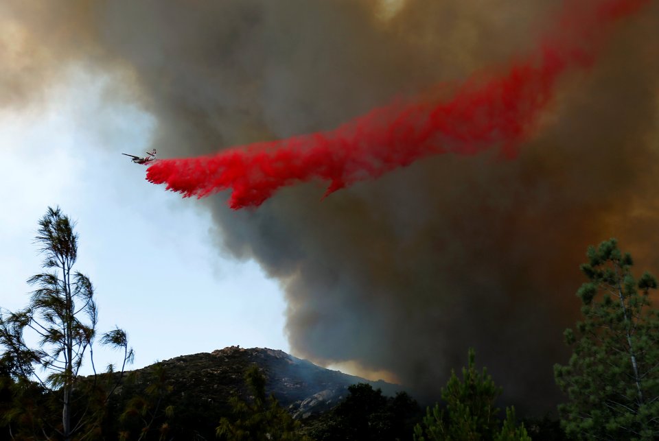 A water bomber makes a drop as firefighters battle a wildfire