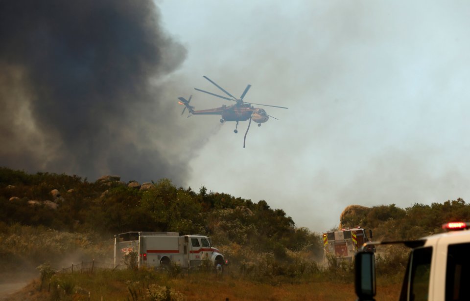 Firefighters battle a wildfire in temperatures well over 100F