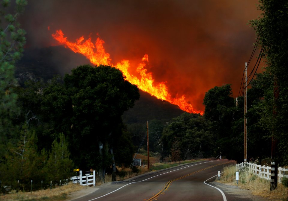 Firefighters battle a wildfire in temperatures well over 100F as it burns near Potero, California,