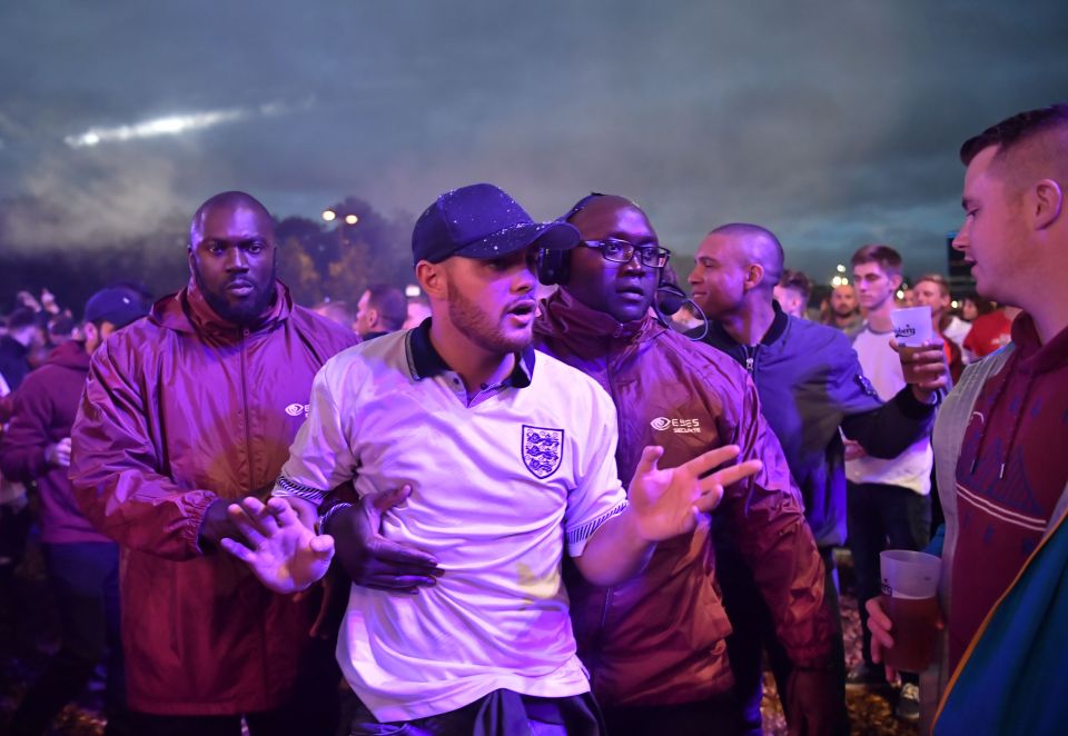 A England supporter gestures as security