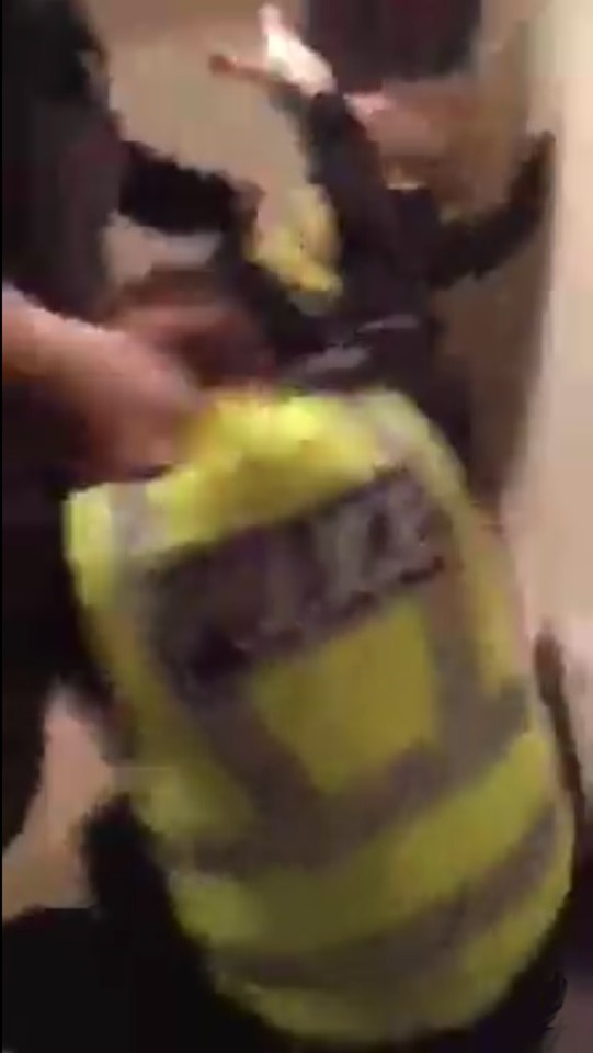 The thugs pull the officer by the collar as they drag him to the floor