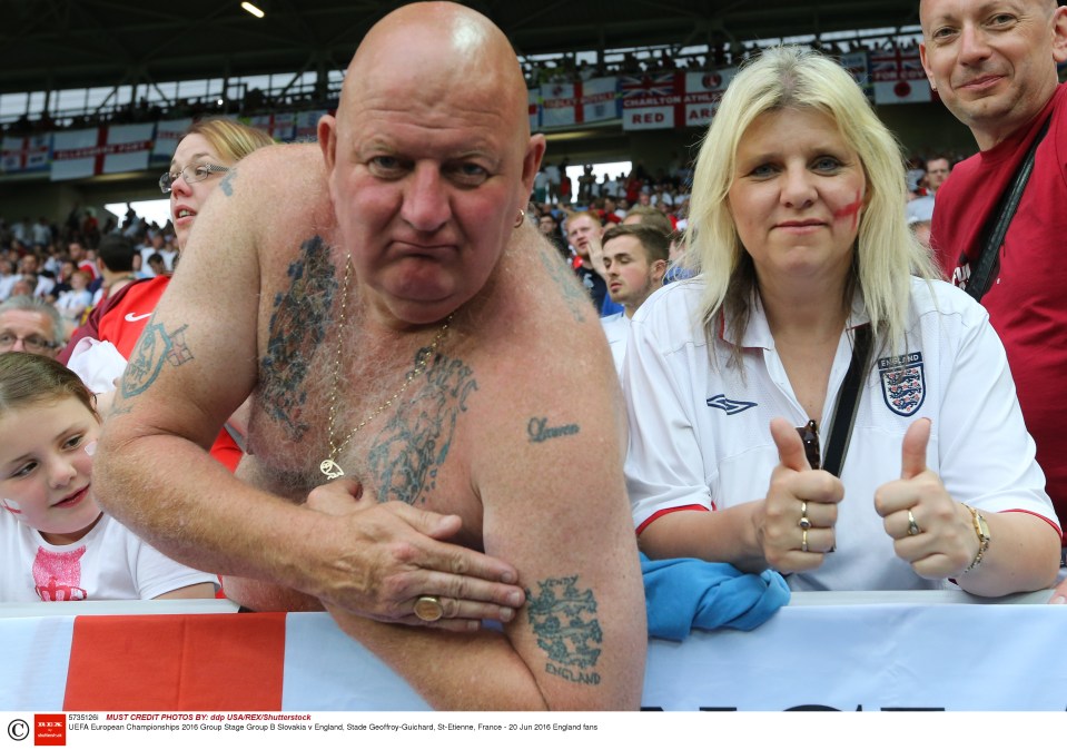  Shirtless supporter proudly shows off his tatts at the England game on Monday