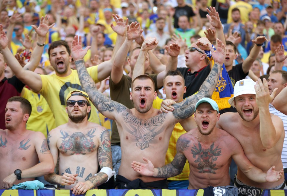  Tattooed Ukraine fans roar on the team from the stands in the match against Poland