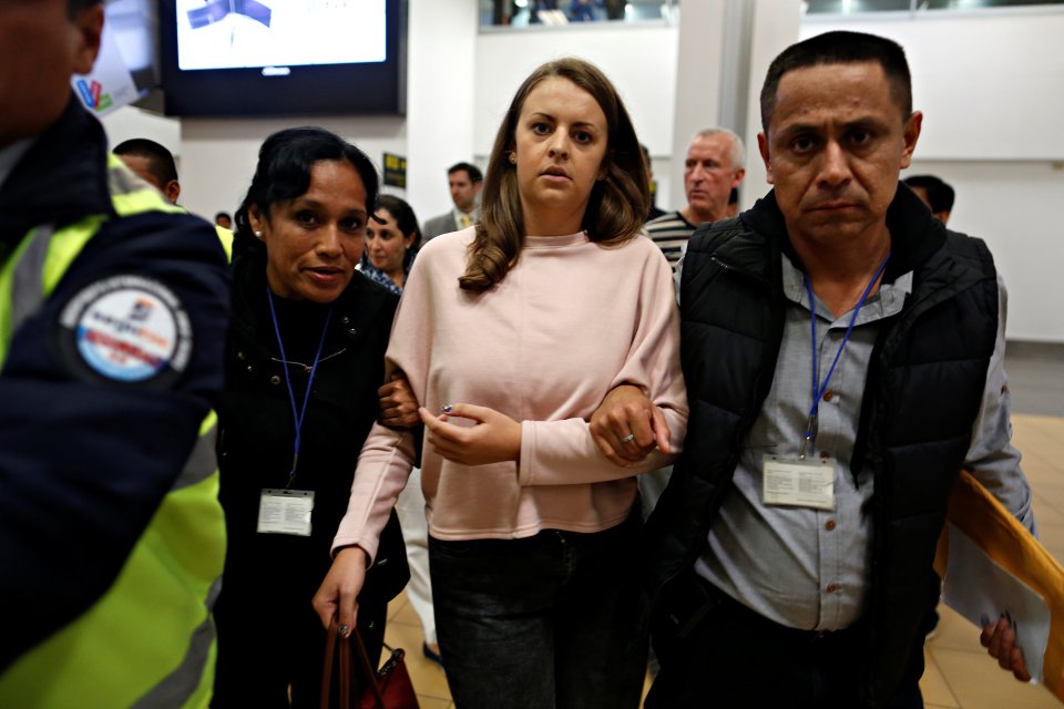 Melissa Reid is escorted by immigration officers before boarding a flight