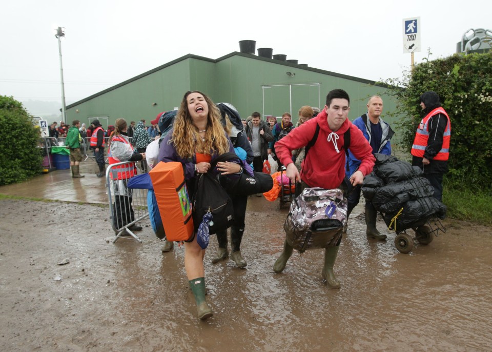  Two friends drag their gear over the rain-sodden ground