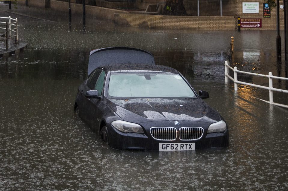  A BMW owner had to drive through high flood water in the south-east of the UK this morning