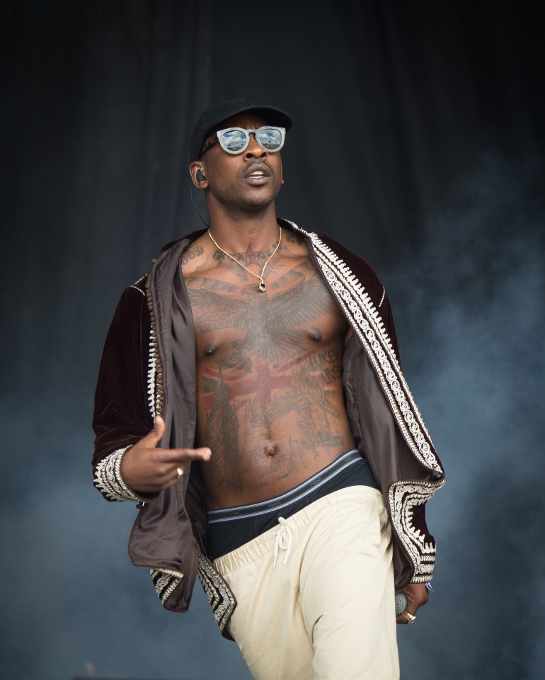 A shirtless Skepta performs