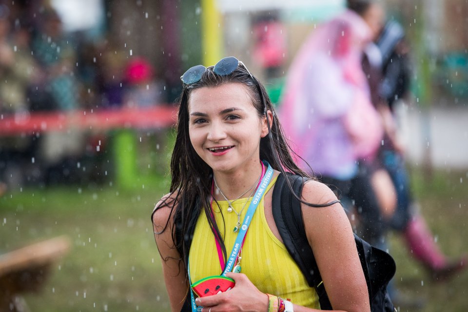  A woman grins as she wanders through the rain - refusing to let the weather put her off enjoying the festival