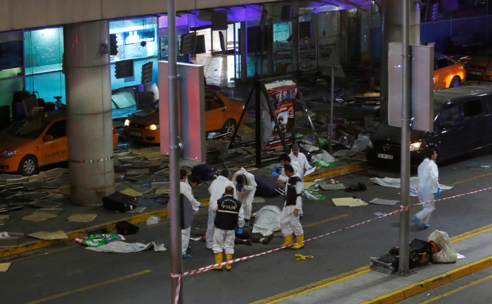  Forensic experts work at the entrance of Turkey's largest airport where the first bomber detonated his vest to drive panicked travellers inside the building