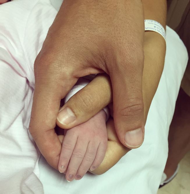  The Watford man holds the hand of his new daughter Matilda