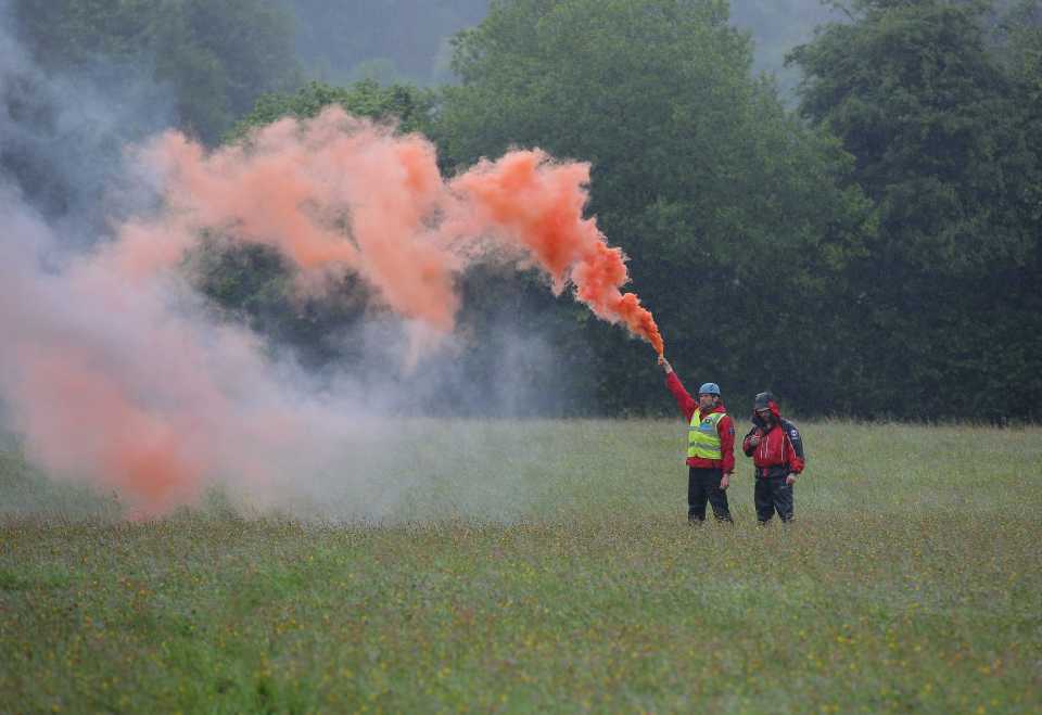  Mountain rescue men with a flare help guide a Coastguard helicopter to its landing site at Tafarn y Gerreg in Powys, Wales