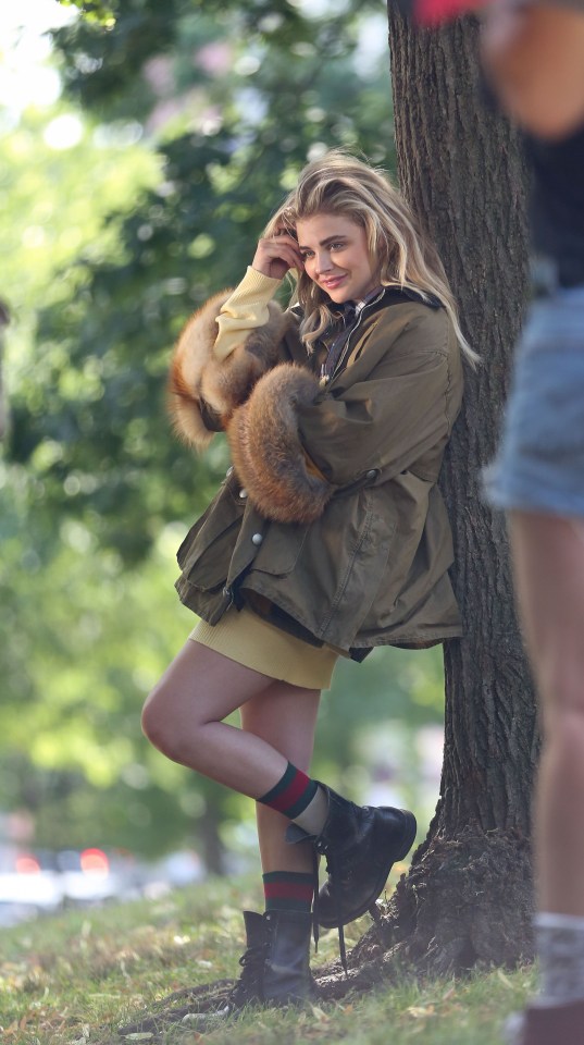  Chloe posed next to a tree in an over-sized parka