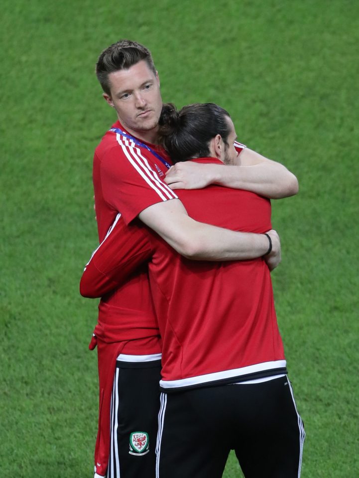 Was it all too much? Gareth Bale gets a cuddle from goalkeeper Wayne Hennessey after his pitch inspection