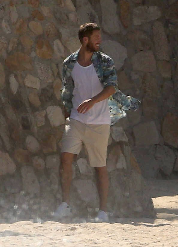  Calvin was dressed casually in shorts, a white vest top and a tropical shirt