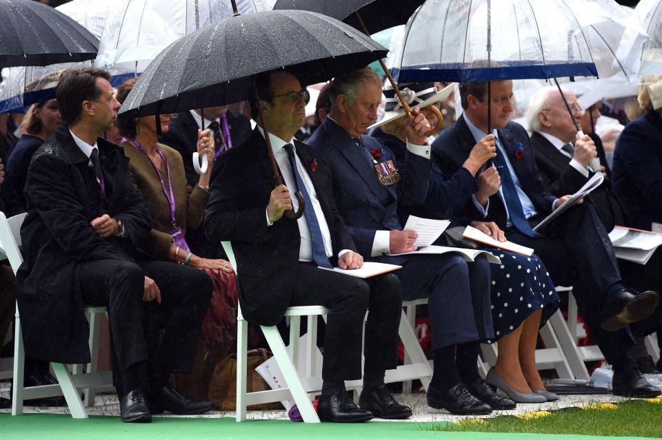  President Francois Hollande, Prince Charles, the Duchess of Conrwall and Prime Minister David Cameron shelter under an umbrellas