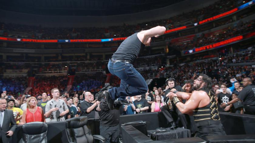 Ambrose launches an elbow at Roman Reigns