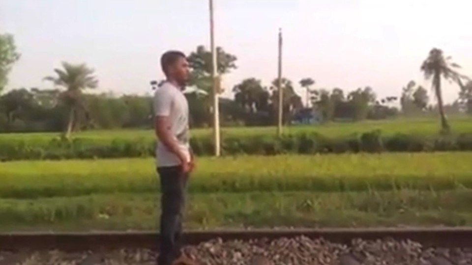 The adrenaline-junkie stands calmly on the train tracks as the train can be heard approaching