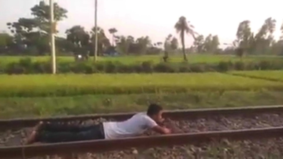 The man even waits until the last second to pull his head down to avoid the train