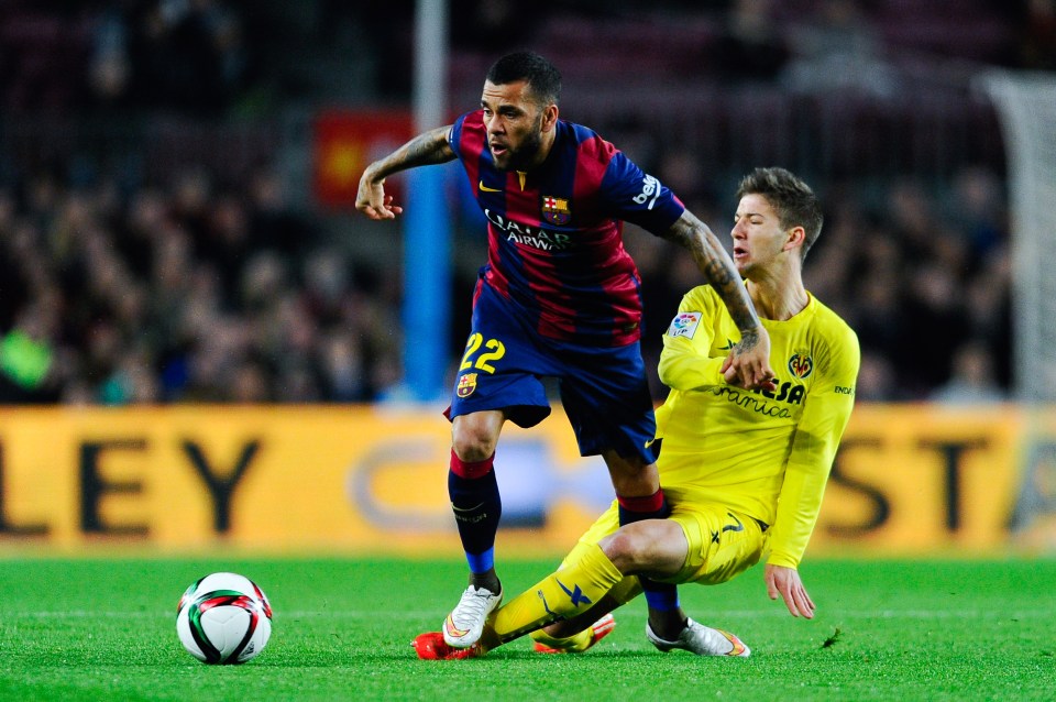 BARCELONA, SPAIN - FEBRUARY 11: Dani Alves of FC Barcelona is brought down by Luciano Vietto of Villarreal CF during the Copa del Rey Semi-Final first leg match between FC Barcelona and Villarreal CF at Camp Nou on February 11, 2015 in Barcelona, Spain. (Photo by David Ramos/Getty Images)