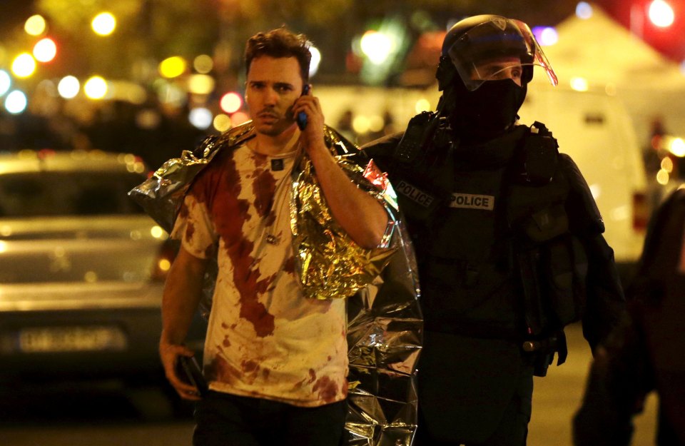  A blood-soaked victim of the Bataclan theatre massacre is escorted to safety by police