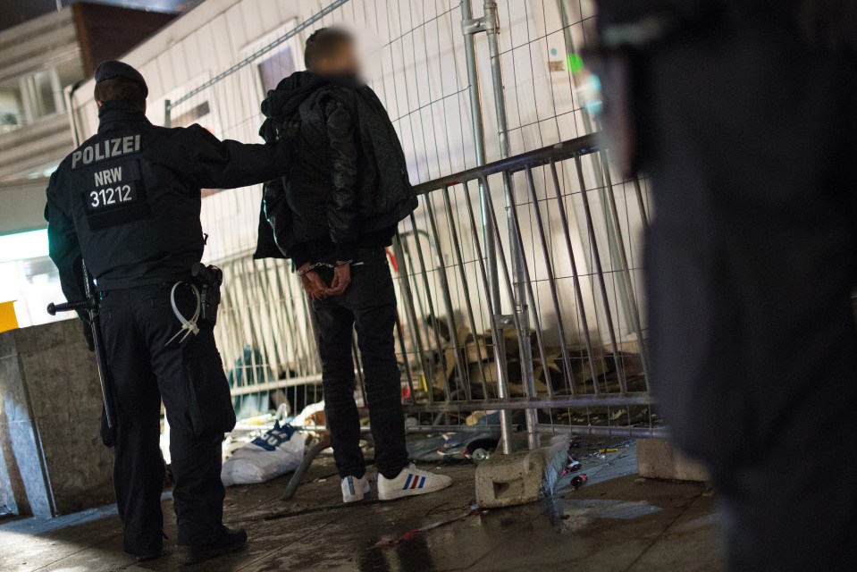  A police officer searches a suspect near the central station in Cologne after the mass assaults