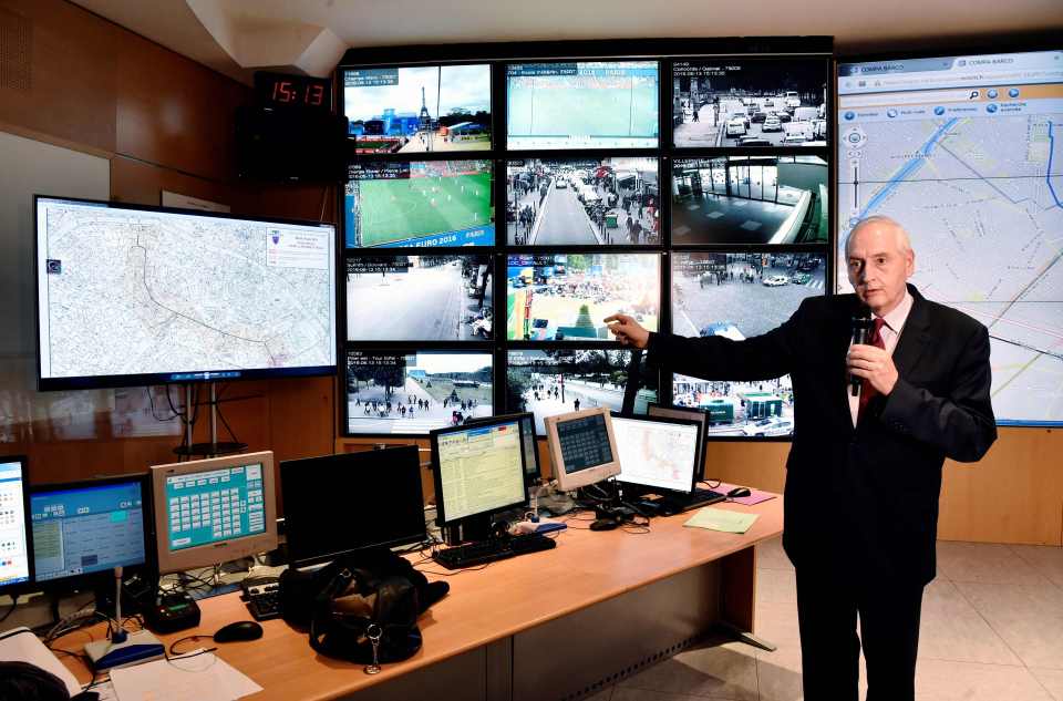  Police chief Michel Cadot standing next to surveillance screens at headquarters