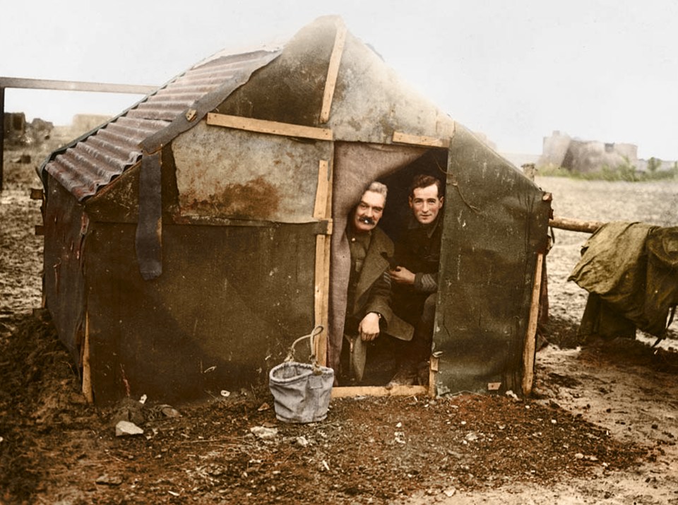  Two officers looking out of a small shelter they appear to have made for themselves