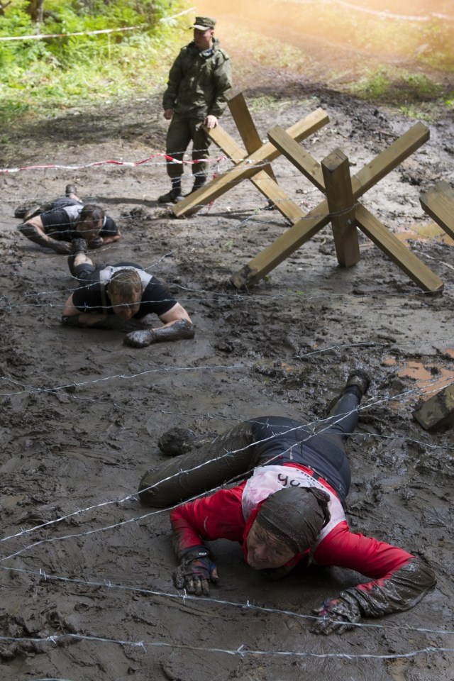 Barbed wire lines sections of the course where competitors are forced to crawl through the dirt