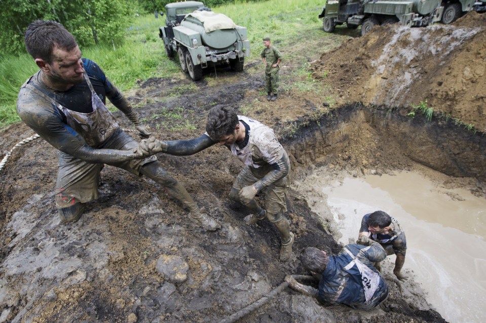 A muddy crater presents a challenge for exhausted runners, who desperately try to clamber out onto dry land