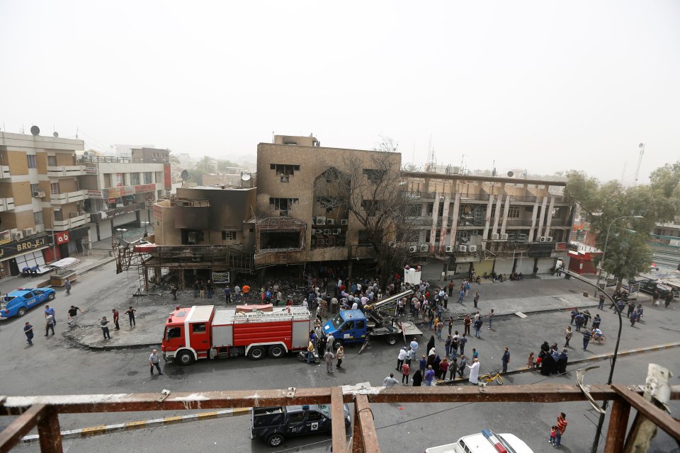  Emergency services and people gather outside the area torn apart by the bomb attack and the subsequent fire