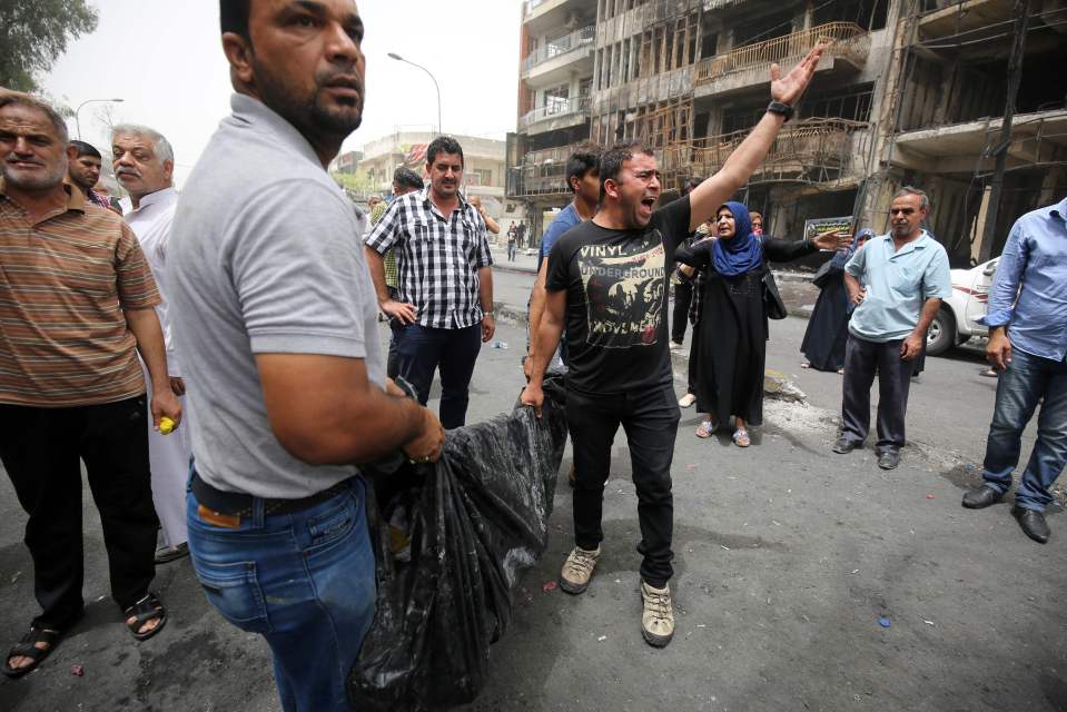  Two man carry a body through the streets the morning after the attack