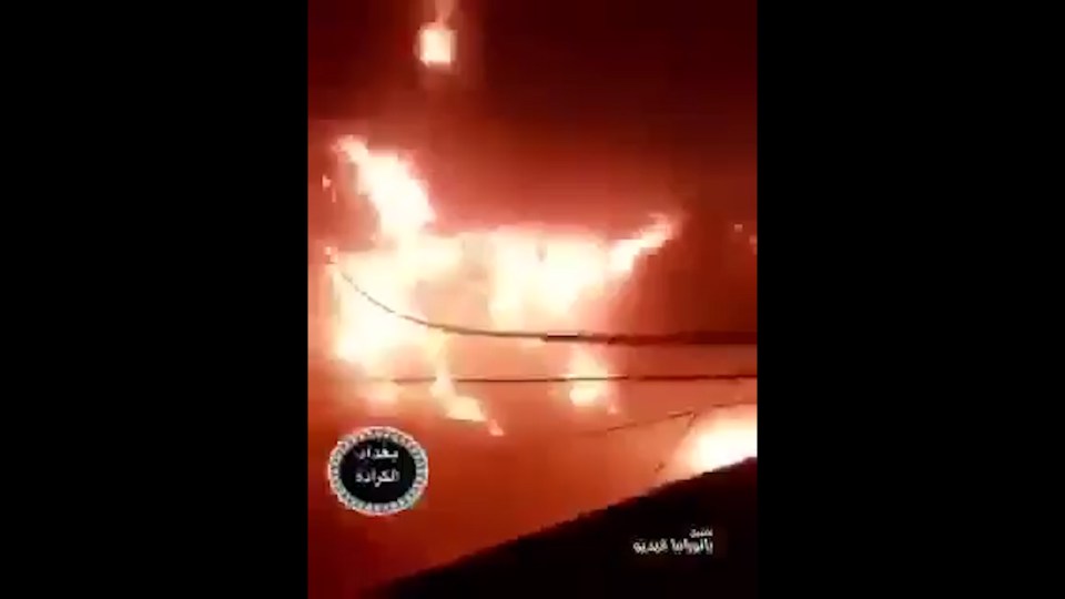  A man films the blaze from the balcony of a nearby building