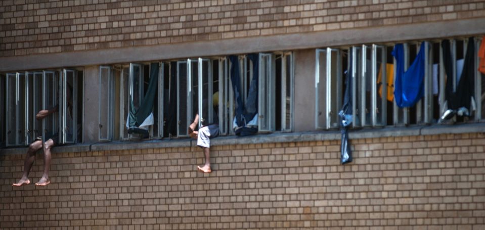  Inmates sit on the window of their cell in the Kgosi Mampuru II