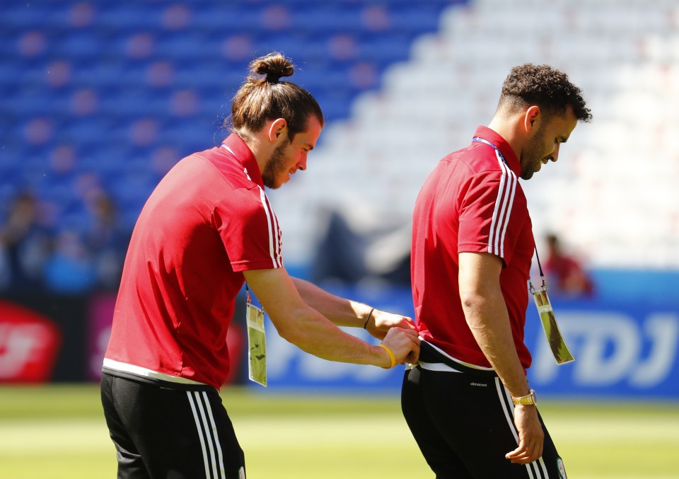  Ashley Williams puts on headphones as the players operate the pitch side camera