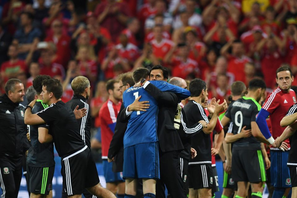 Wales' coach Chris Coleman (C) embraces Wales' goalkeeper Wayne Hennessey at the end of the Euro 2016 semi-final football match between Portugal and Wales at the Parc Olympique Lyonnais stadium in Décines-Charpieu, near Lyon, on July 6, 2016. / AFP PHOTO / PAUL ELLISPAUL ELLIS/AFP/Getty Images