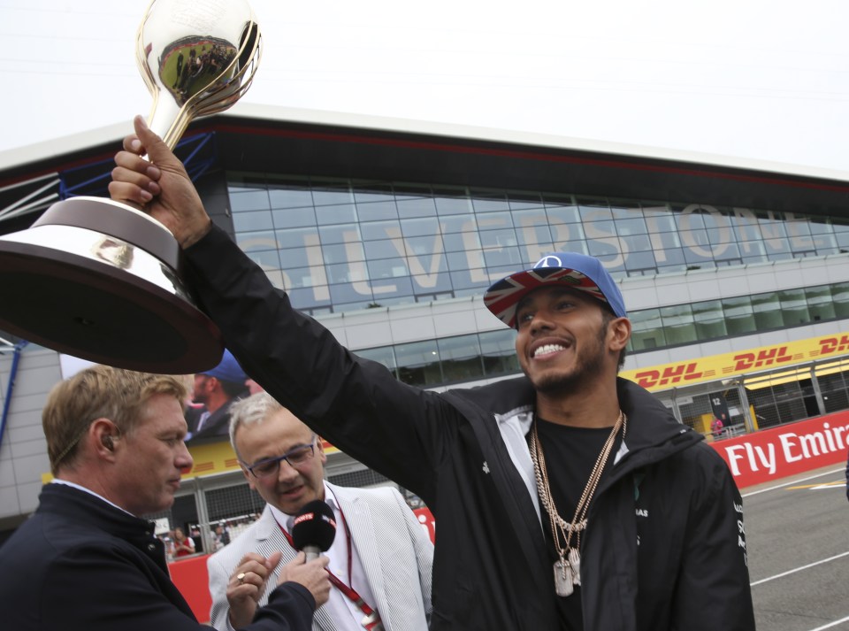 Lewis Hamilton poses with the Hawthorn trophy with fans at Silverstone