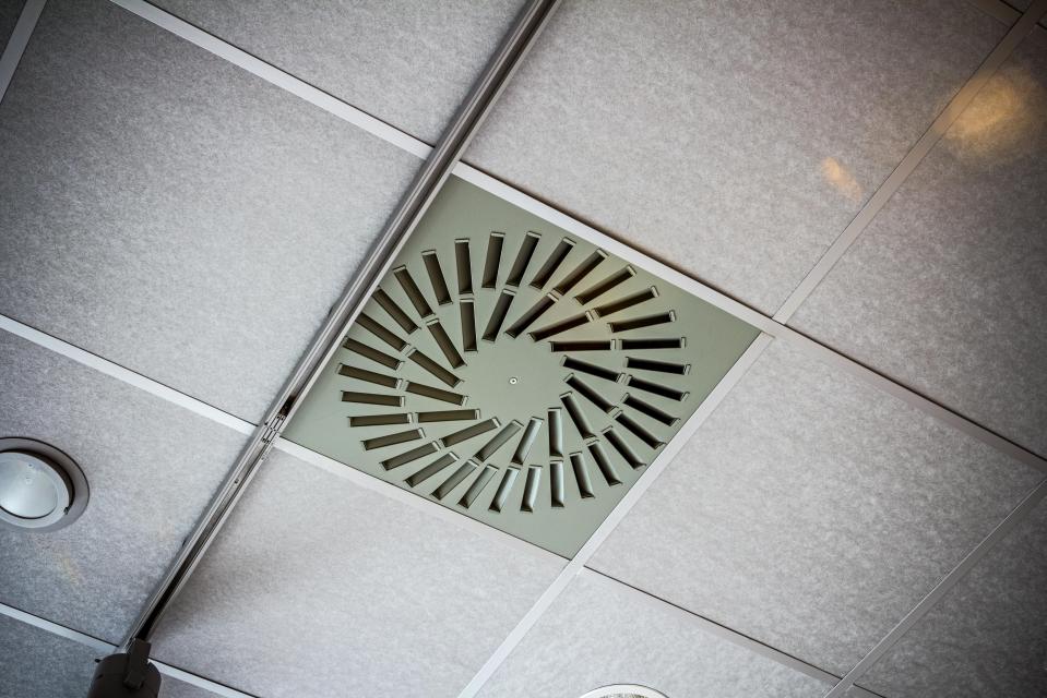 Office ceiling has modern light and the hatch for conditioning system ventilation.