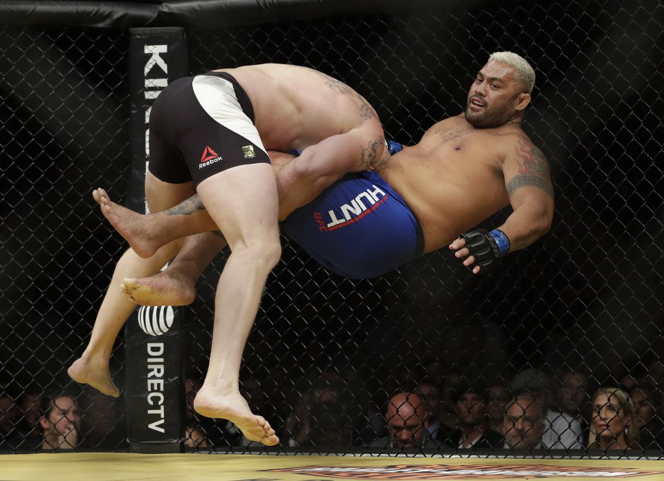 Brock Lesnar, left, takes down Mark Hunt during his victory